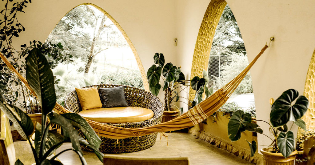 Indoor/outdoor space with rattan chair and hammock
