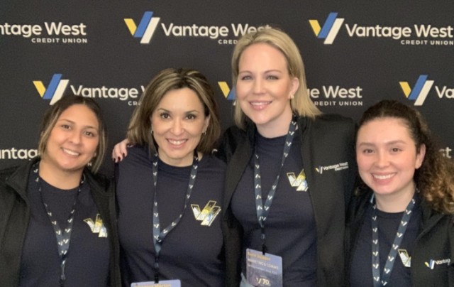 Group photo of Vantage West staff in front of Vantage West backdrop