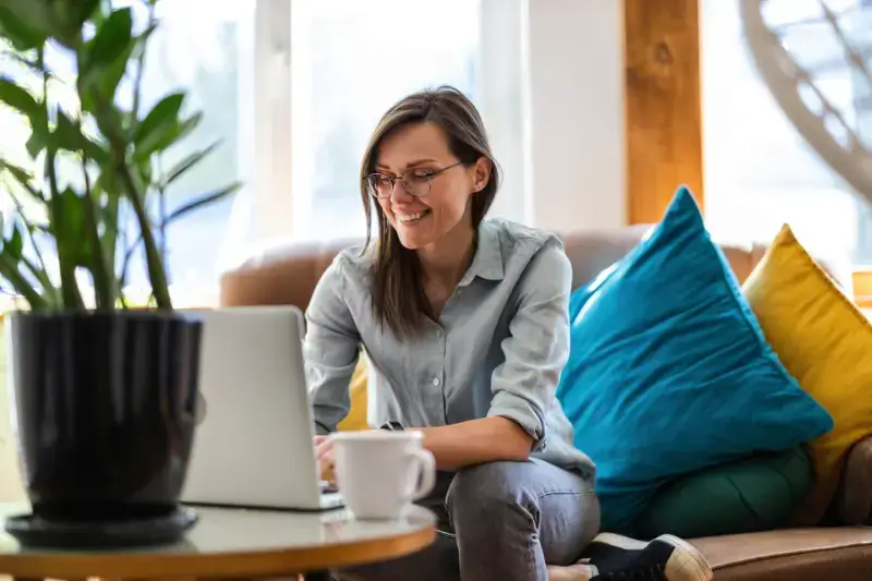 Woman happily using her computer at home